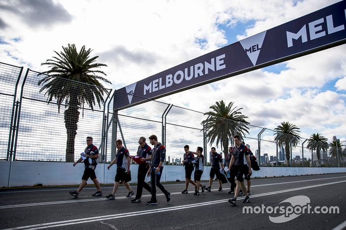 Romain Grosjean camina por la pista junto a miembros del equipo Haas