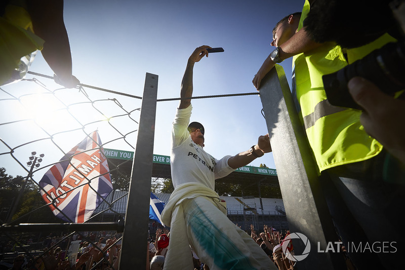 Lewis Hamilton, Mercedes AMG F1, takes a photo, fans