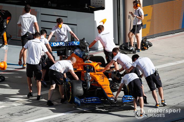 Los mecánicos empujan a Daniel Ricciardo, McLaren MCL35M, de vuelta al garaje