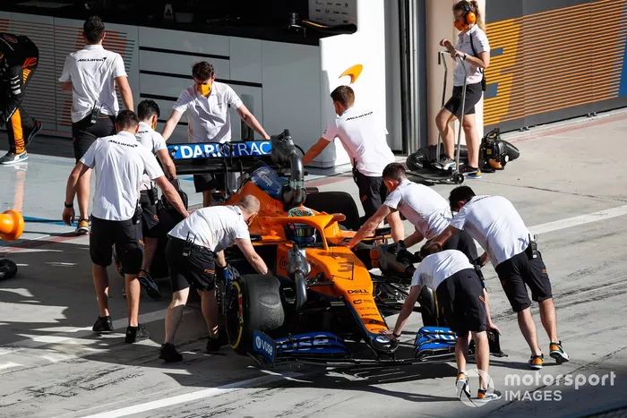 Los mecánicos empujan a Daniel Ricciardo, McLaren MCL35M, de vuelta al garaje