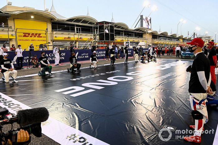 Los conductores se arrodillan o se ponen de pie en apoyo de la campaña Fin del Racismo
