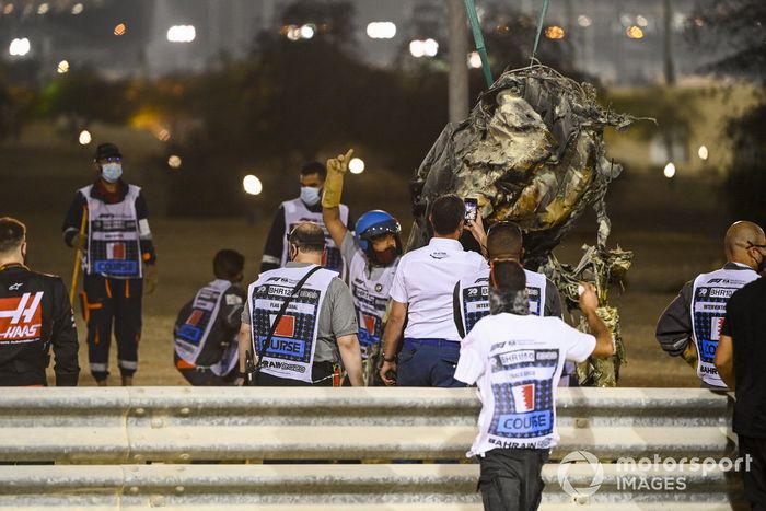 Los oficiales retiran los restos del monoplaza de Romain Grosjean, Haas VF-20, después del accidente en la primera vuelta