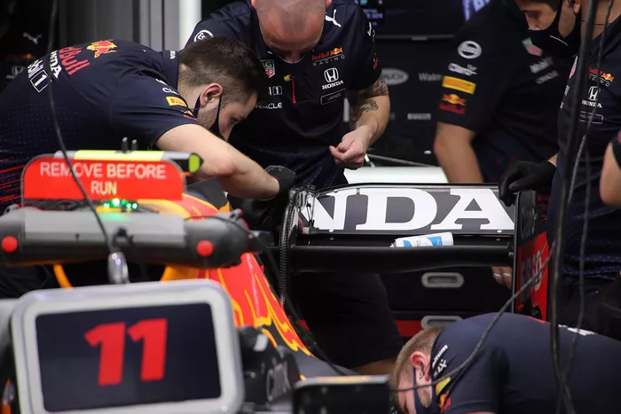 Miembros del equipo Red Bull Racing trabajando en el alerón trasero