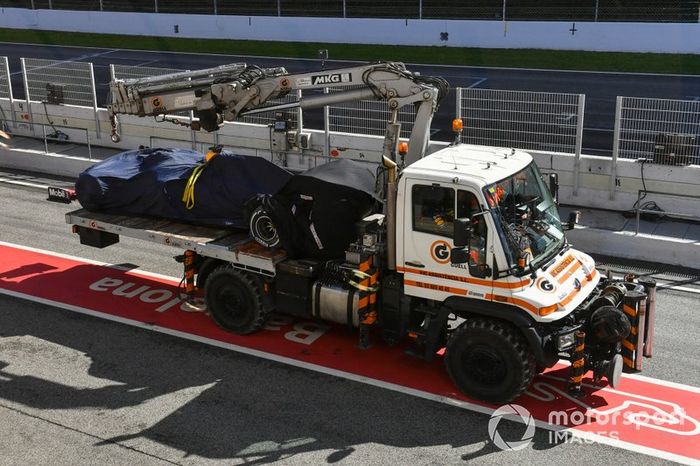 El monoplaza de Max Verstappen Red Bull Racing RB16 es devuelto a los boxes en la parte trasera de una grúa