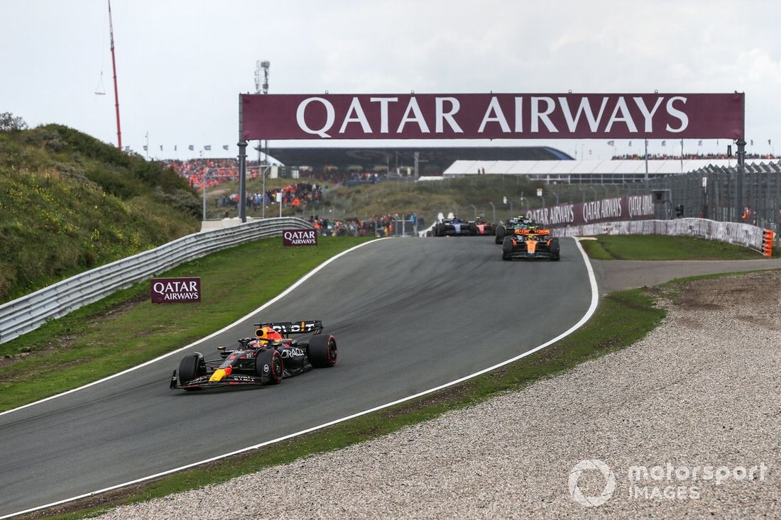 Max Verstappen, Red Bull Racing RB19, lidera Lando Norris, McLaren MCL60, Fernando Alonso, Aston Martin AMR23, y el resto de la parrilla en la primera vuelta.