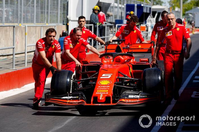 I meccanici Ferrari spingono la monoposto di Sebastian Vettel, Ferrari SF90 lungo la pit lane