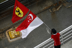 A fan waves flags in support of Singapore and Ferrari