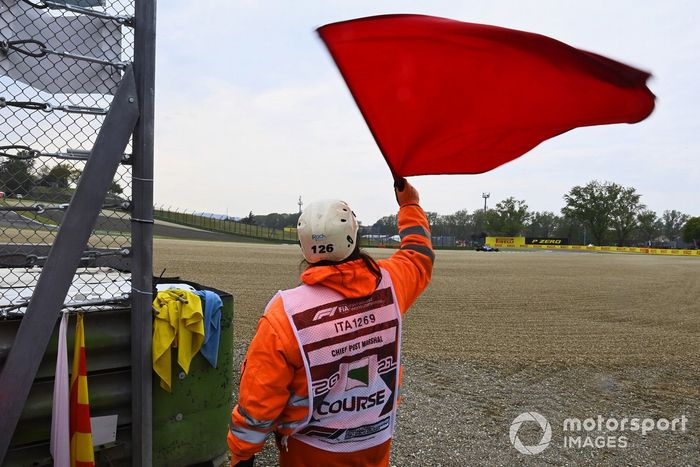 Un oficial de pista agita la bandera roja