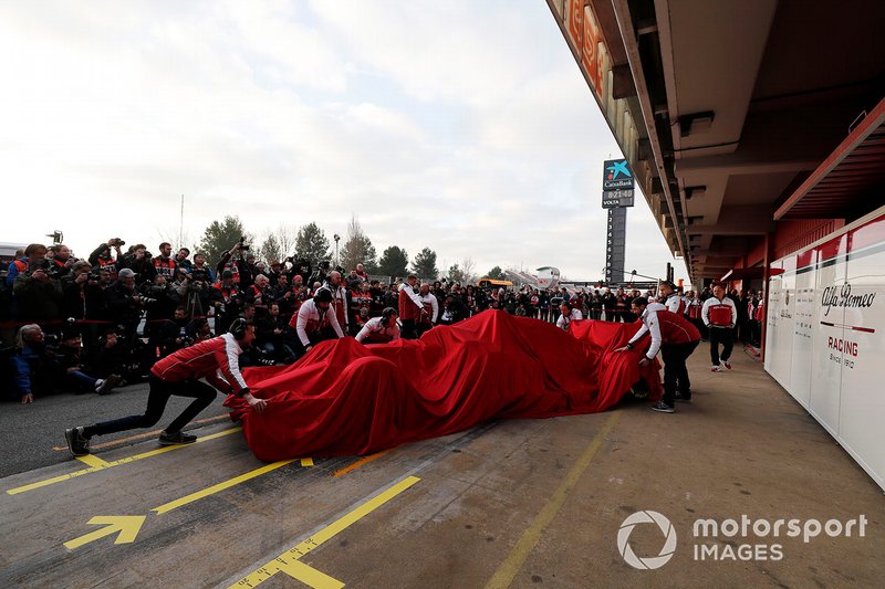 Meccanici Alfa Romeo Racing con l'Alfa Romeo Racing C38, sotto al telo