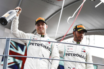 Valtteri Bottas, Mercedes AMG F1, third position, and Lewis Hamilton, Mercedes AMG F1, first position, celebrate with Champagne on the podium