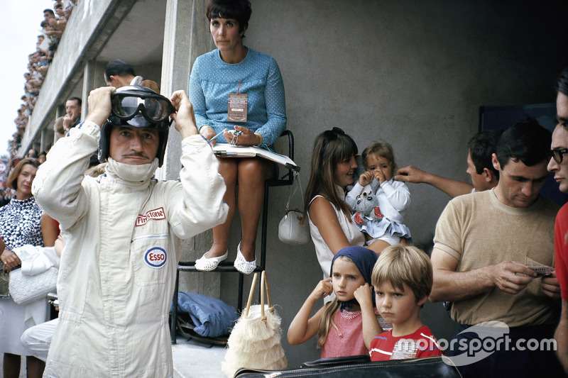 Graham Hill se prepara para competir en boxes, rodeado de su familia: su esposa Bette Hill y una niñera que cuida a los tres niños - más adelante F1 mundo campeón Damon