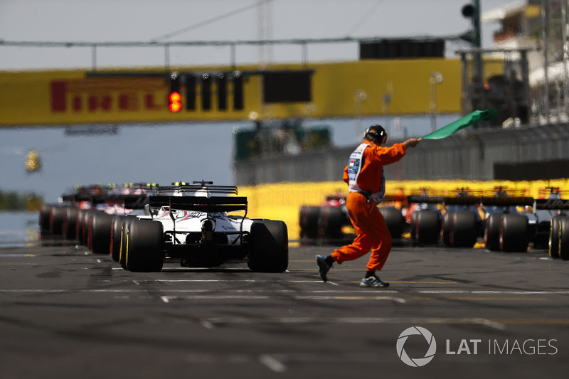 The lights come on and a marshal gives the green flag for the start