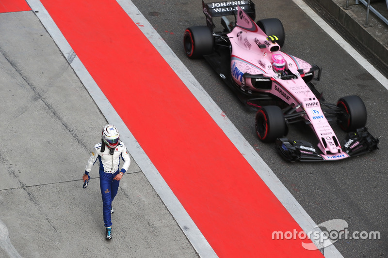 Antonio Giovinazzi, Sauber C36, is passed in the pit lane by Esteban Ocon, Force India VJM10, after 