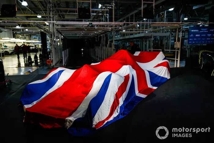 El Aston Martin AMR22 en el escenario bajo una bandera de la Gran Bretaña