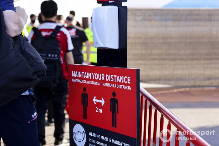 Una señal que recuerda la necesidad de mantener la sana distancia en el paddock