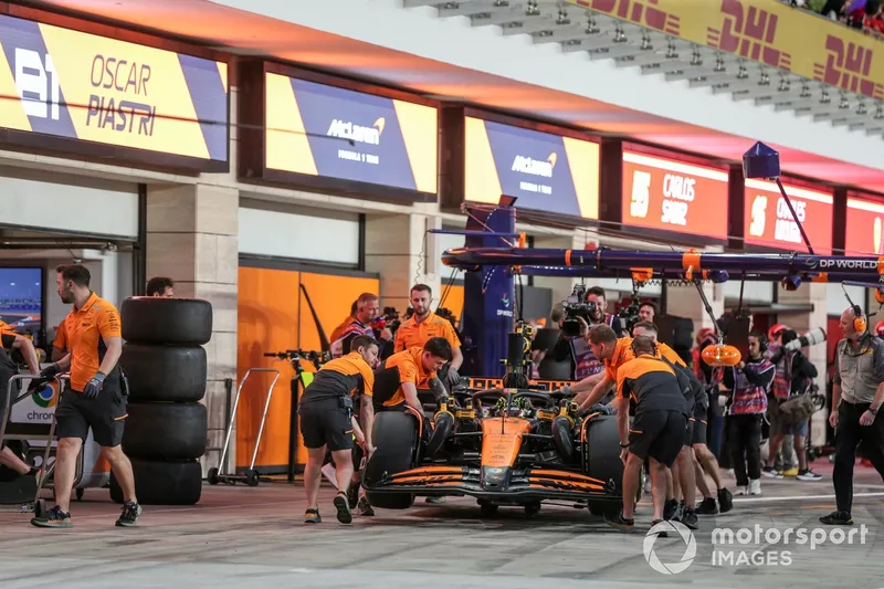 Les mécaniciens ramènent Lando Norris, McLaren MCL38, au garage