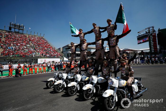Un equipo de exhibición de motos actúa para el público antes de la salida
