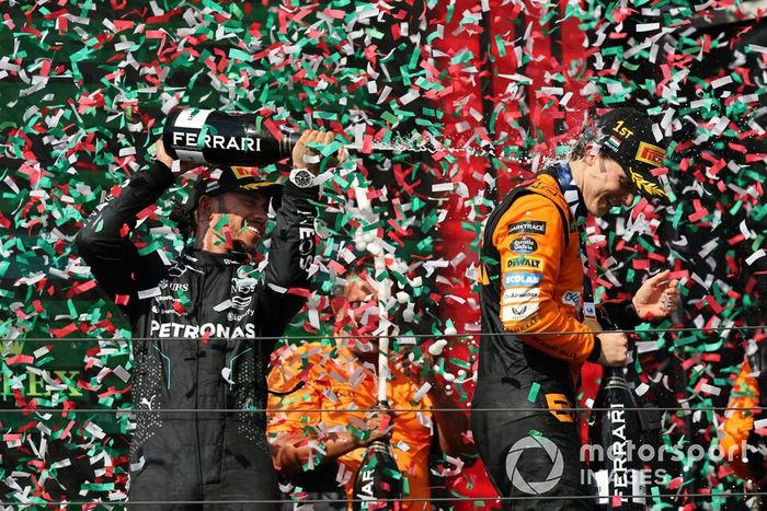 Lewis Hamilton, Mercedes-AMG F1 Team, 3ª posición, rocía a Oscar Piastri, McLaren F1 Team, 1ª posición, con champán en el podio.