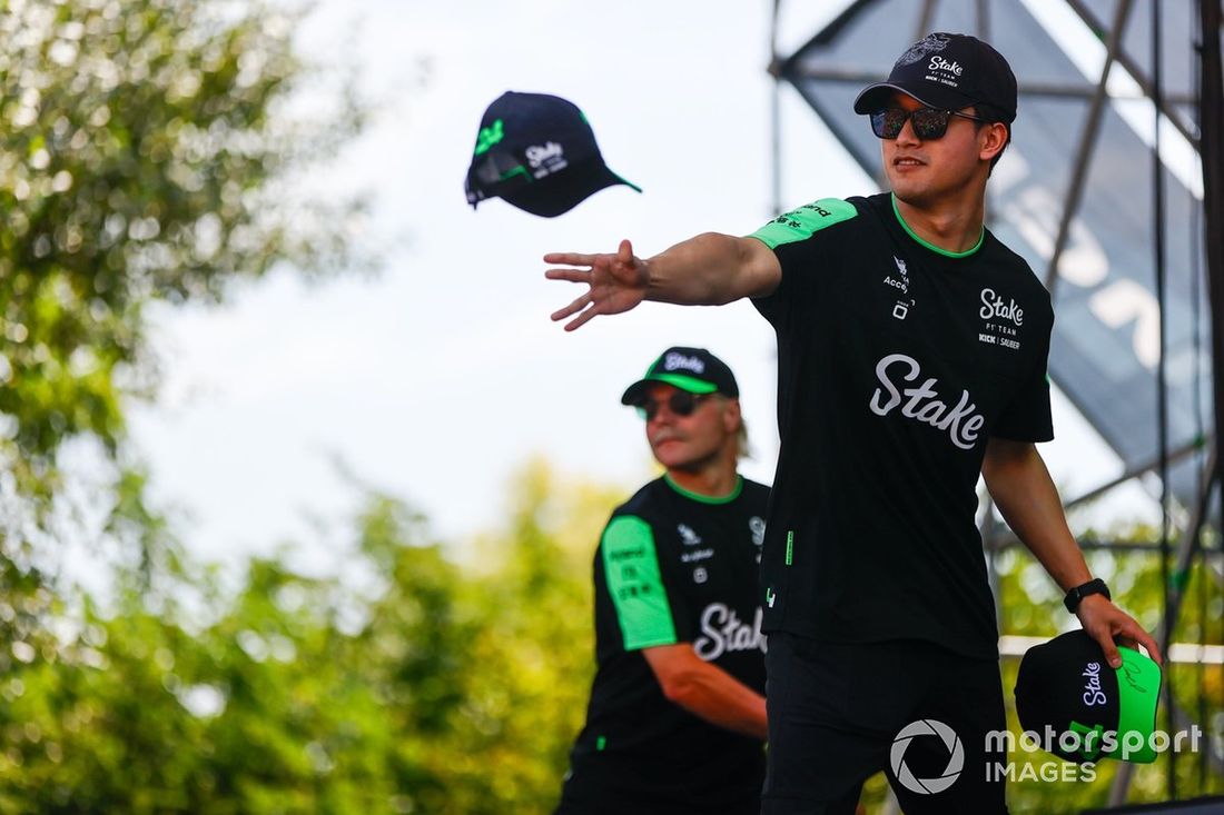 Zhou Guanyu, Stake F1 Team Kick Sauber, lanza gorras a los aficionados. Valtteri Bottas, del equipo Stake F1 Team Kick Sauber, se coloca detrás.
