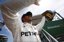 Гонщик Mercedes AMG F1 Льюис Хэмилтон показывает болельщикам подаренный ему шлем Айртона Сенны