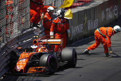 Les commissaires nettoient les débris de la voiture de Stoffel Vandoorne, McLaren MCL32, après son crash