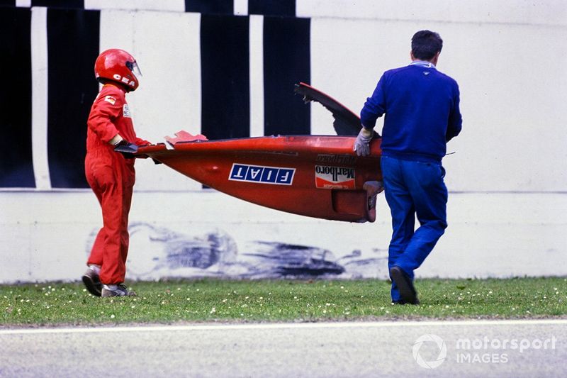 Los oficiales se llevan la carrocería trasera del Ferrari 640 de Gerhard Berger después de un accidente