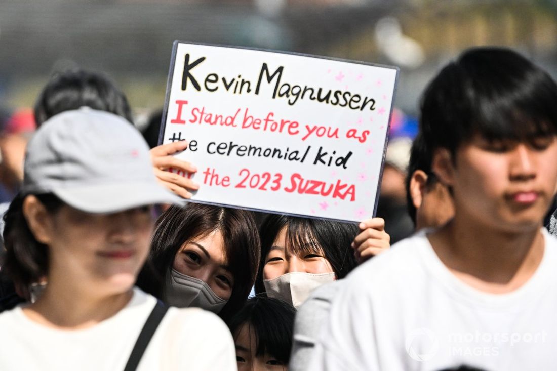 Adeptos japoneses seguram um cartaz de Kevin Magnussen, da Haas F1 Team