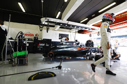 Jenson Button, McLaren MP4-31 en el garaje, con su coche se trabajó