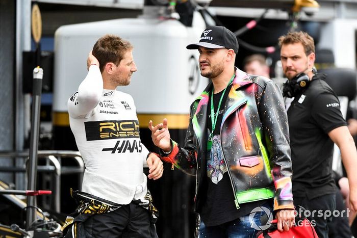 Romain Grosjean conversa com convidado no paddock de Mônaco