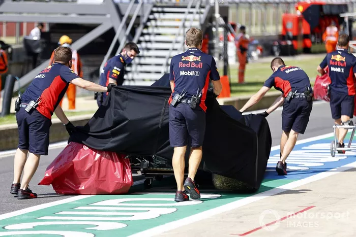 Los mecánicos de Red Bull con el monoplaza dañado de Alex Albon, Red Bull Racing RB16 en el garaje bajo una lona después de su accidente en la FP2