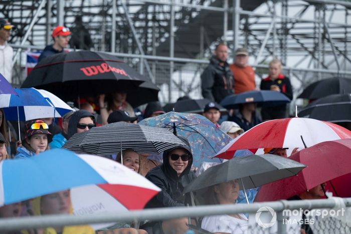 Aficionados bajo paraguas en una tribuna