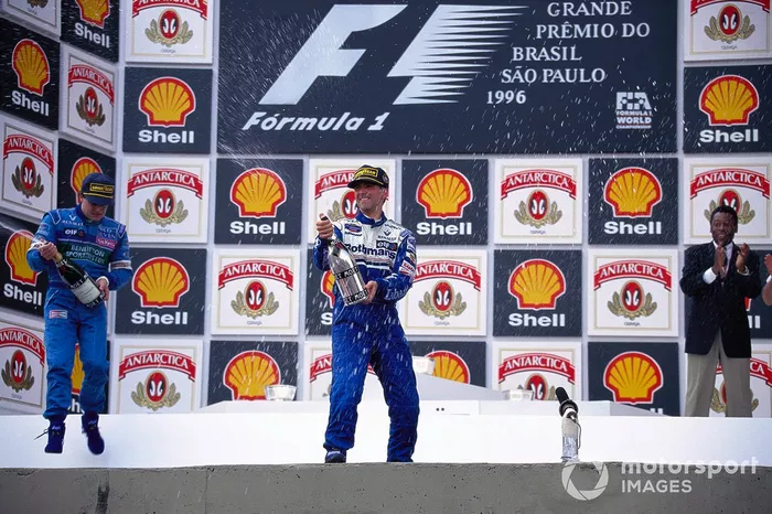 Damon Hill celebra la victoria en el podio con Jean Alesi y la leyenda del fútbol brasileño Pelé.