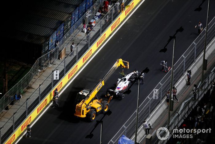 Los oficiales de pista retiran el coche dañado de Nikita Mazepin, Haas VF-21