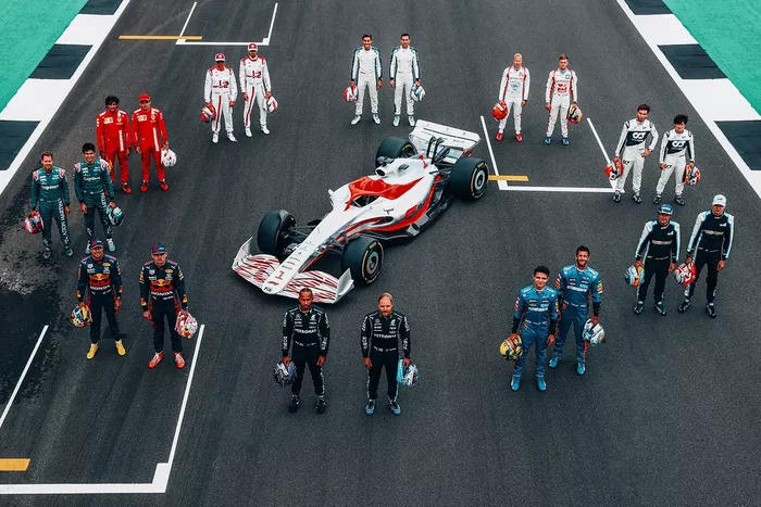 Foto de grupo de los pilotos con el coche de F1 de 2022