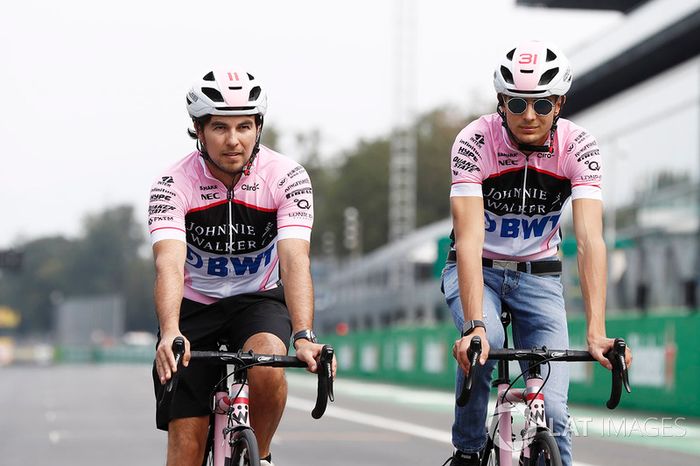 Esteban Ocon, Force India y Sergio Pérez, Force India, andan por el circuito en bicicleta