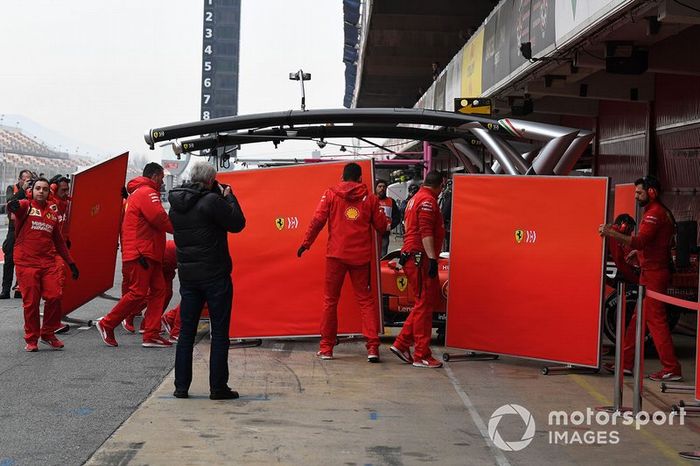 Sebastian Vettel, Ferrari SF90 y mecánicos de Ferrari con paneles para tapar su coche de la vista de los curiosos