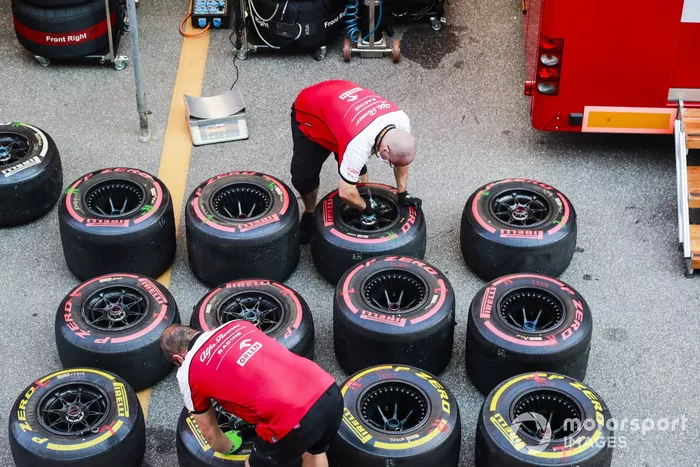 Los mecánicos de Alfa Romeo trabajan en algunos neumáticos