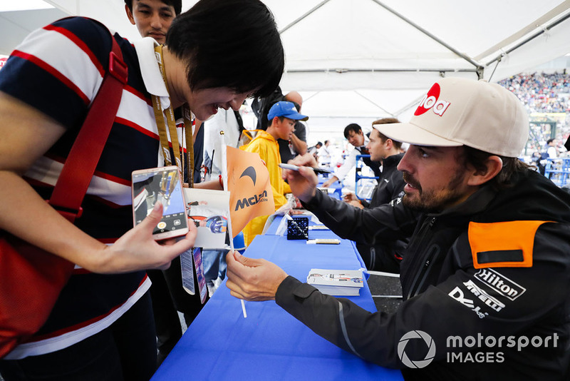 Fernando Alonso, McLaren, signs an autograph for a fan