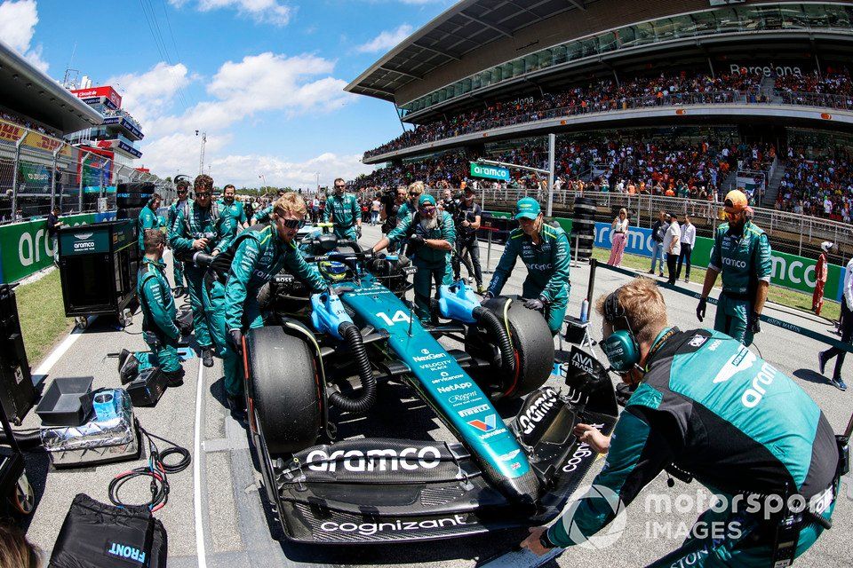 Mechanicy McLarena pchają Fernando Alonso, Astona Martina AMR24, na jego miejsce startowe