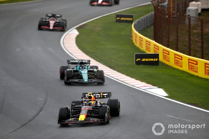 Sergio Pérez, Red Bull Racing RB19, por delante de Lance Stroll, Aston Martin AMR23, y Valtteri Bottas, Alfa Romeo C43.