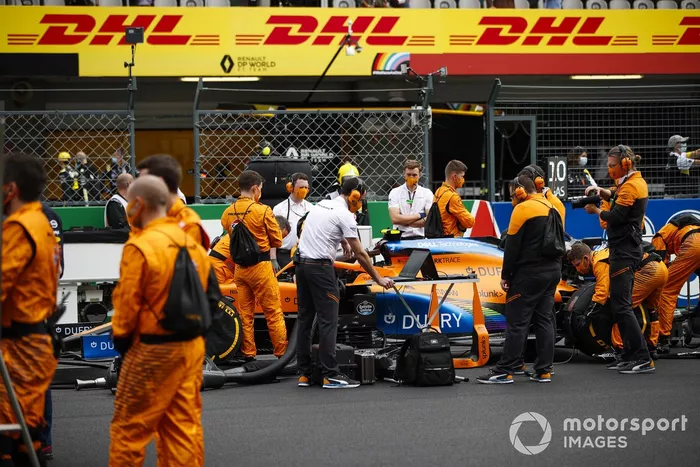 Mecánicos en la parrilla con el coche de Lando Norris, McLaren MCL35