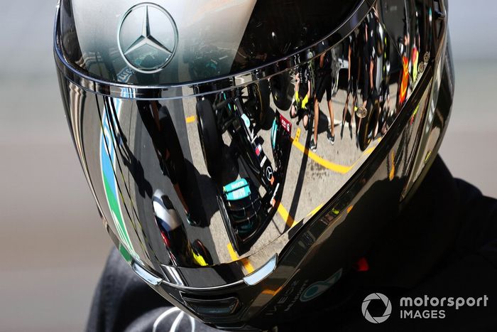 El coche de Lewis Hamilton, Mercedes W12, reflejado en el casco de un mecánico