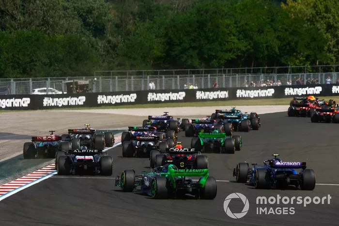 Esteban Ocon, Alpine A524, Sergio Perez, Red Bull Racing RB20, Zhou Guanyu, Stake F1 Team Kick Sauber C44, Logan Sargeant, Williams FW46, persiguen al pelotón en la primera vuelta.