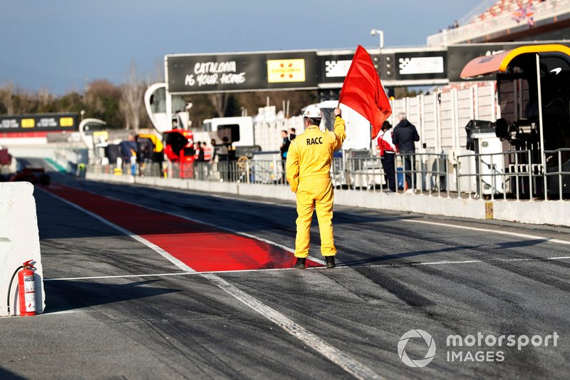 Un marshal sventola la bandiera rossa in pit lane