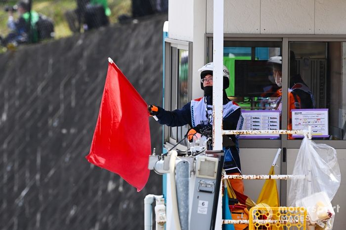 Un comisario agita una bandera roja durante los entrenamientos finales