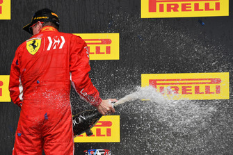 Il vincitore della gara Kimi Raikkonen, Ferrari, festeggia sul podio con lo champagne e il trofeo