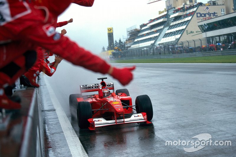 Michael Schumacher, Ferrari F1-2000, celebrates victory with his mechanics at the end of the race