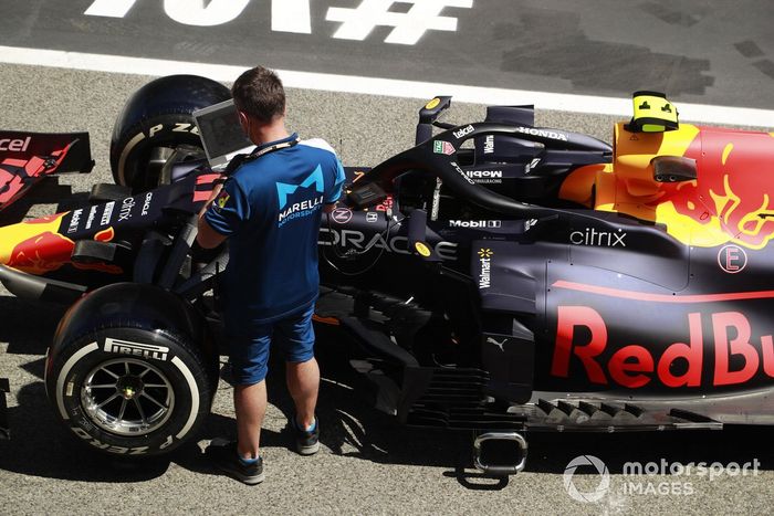 Un empleado de Marelli Motorsport trabaja en el Red Bull Racing RB16B de Sergio Pérez 