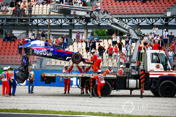 Marshals remove the damaged car of Brendon Hartley, Toro Rosso STR13, from the circuit as the gearbox hangs off the back