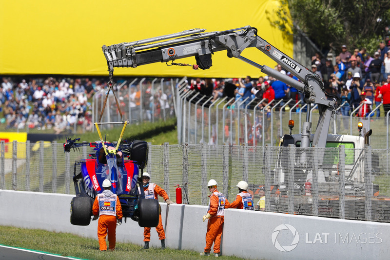 El coche dañado de Pierre Gasly, Toro Rosso STR13, es retirado de la pista por oficiales